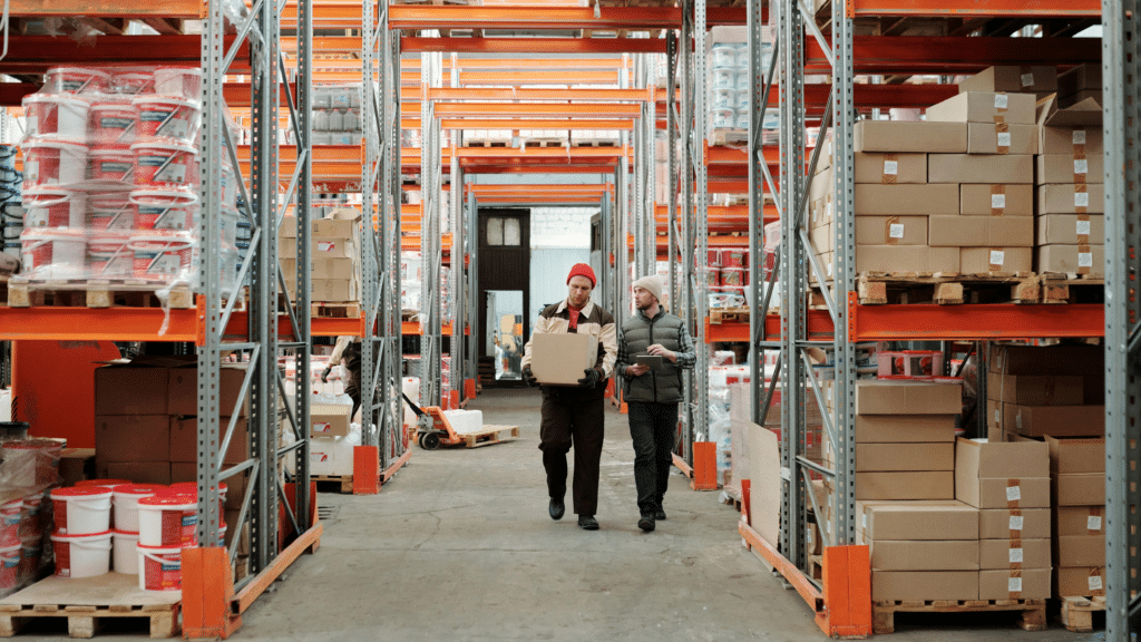 Two workers moving inventory in warehouse, reviewing stock for valuation methods